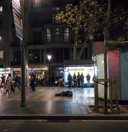 pessoa em situação de rua, na calçada da cidade, à noite... rua movimentada de pedestres passando